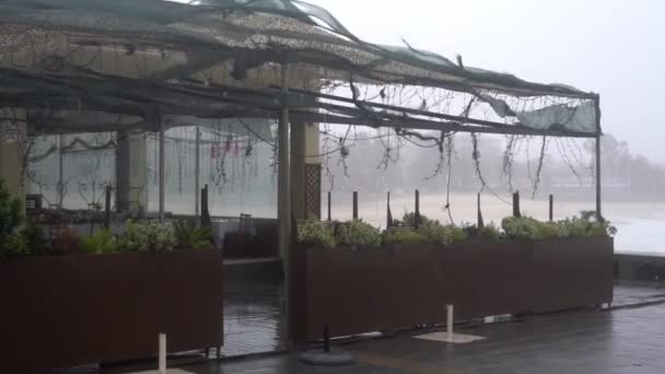 Kawiarnia uliczna na nabrzeżu z dachem zniszczonym przez wiatr — Wideo stockowe