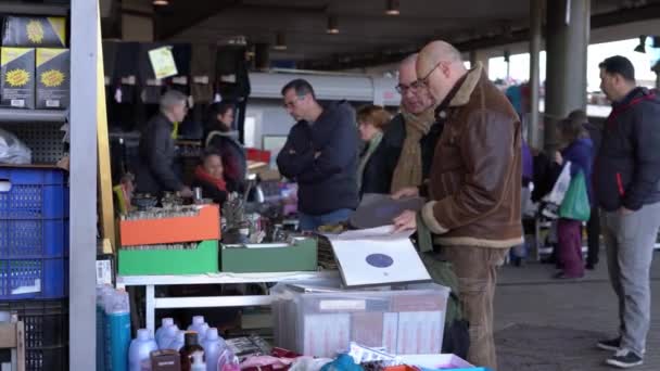 Men buy vinyl records in the market. Sale of old vinyl records at a flea market — Stock Video