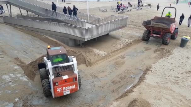 Egy traktor homokot rak egy szemeteskocsiba a part menti felépülés során, vihar után.. — Stock videók