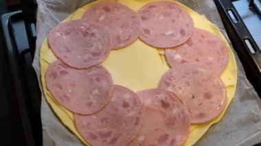 Aşçı hamura peynirli jambon koyar.