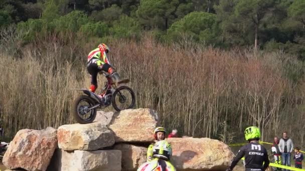 Motocyklista skočí na zkušební motocykl pro zkoušku na obrovském kameni — Stock video