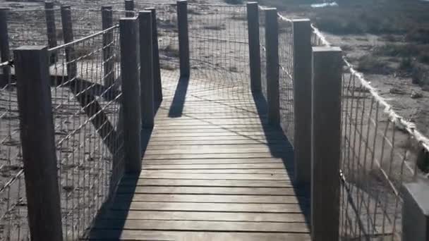 Yüksek ahşap bir köprüde yürüyor halat korkuluklarla — Stok video