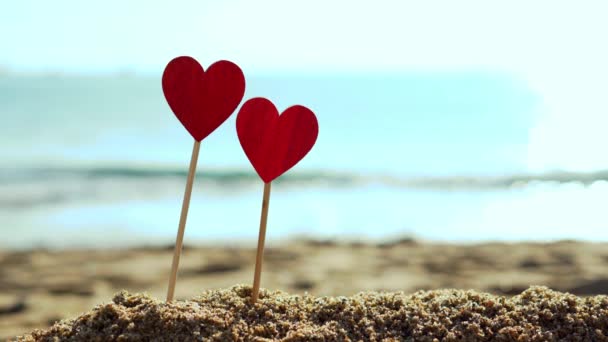 Dos hermosos corazones rojos de madera sobre un fondo del mar . — Vídeos de Stock