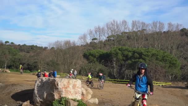 Atleta en una motocicleta pasea delante de la cámara durante un motocross — Vídeo de stock