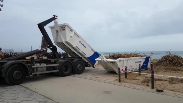 Un camion scarica un container per raccogliere alghe e detriti dopo una tempesta . — Video Stock