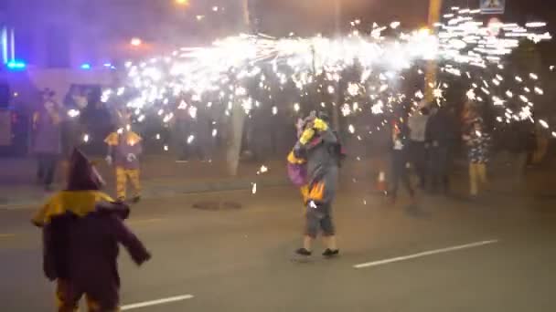 Gente con disfraces de diablo baila por la noche en la calle con muchas luces — Vídeos de Stock