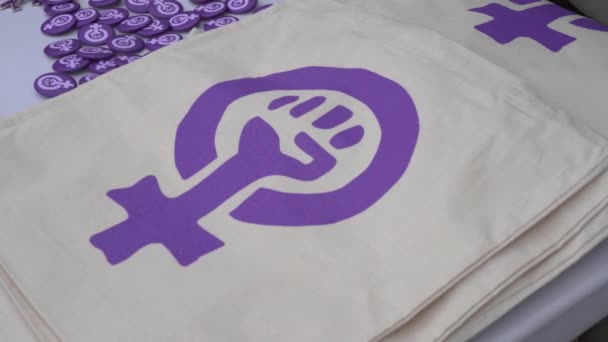 Значки и сумки с феминистскими атрибутами на прилавке на улице — стоковое видео