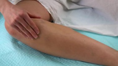 Varis damarlarından muzdarip bir kadın bacağını varisle okşuyor.