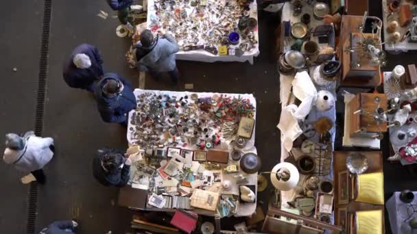 Mensen in een vlooienmarkt overwegen een assortiment van vintage dingen — Stockvideo
