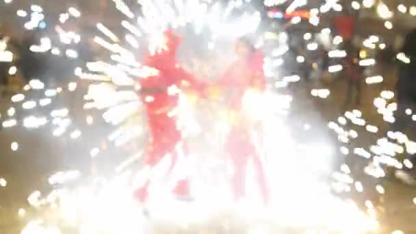 Человек с факелом от фейерверка, танцующий ночью во время пожарной процессии — стоковое видео
