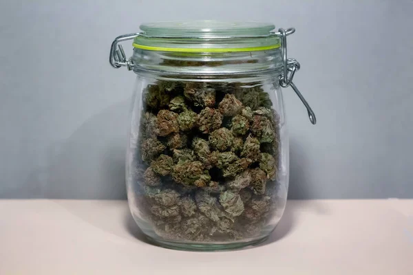 Un frasco de conservas con un sello verde cerrado, lleno de marihuana —  Fotos de Stock