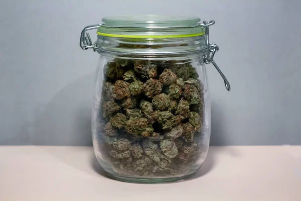 Un pot de conserve avec un sceau vert verrouillé serré, plein de marijuana — Photo