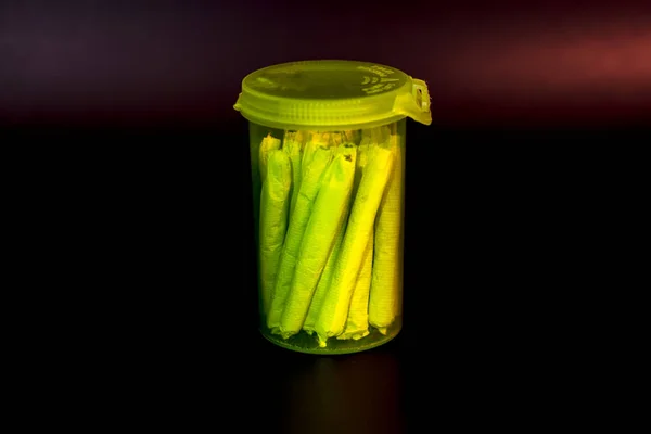 Uma garrafa de pílula RX verde transparente brilhante cheia de maconha — Fotografia de Stock