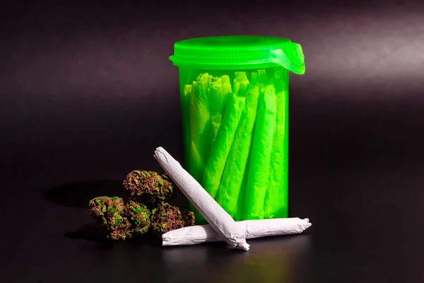 Eine leuchtend durchsichtige grüne rx-Pillenflasche mit Marihuana-Joints — Stockfoto