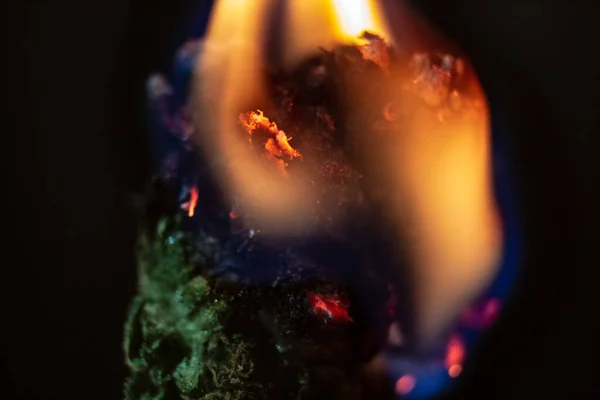 A marijuana bud consumed in flame, isolated macro close up. — Stock Photo, Image