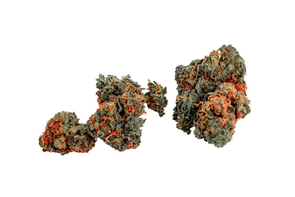 Beyaz bir sırtın önünde hareketli bir marihuana tomurcuğu yığını.