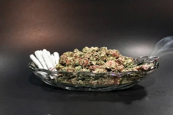 Шикарное стеклянное блюдо с бутоном марихуаны, ножницами и дюжиной косяков — стоковое фото