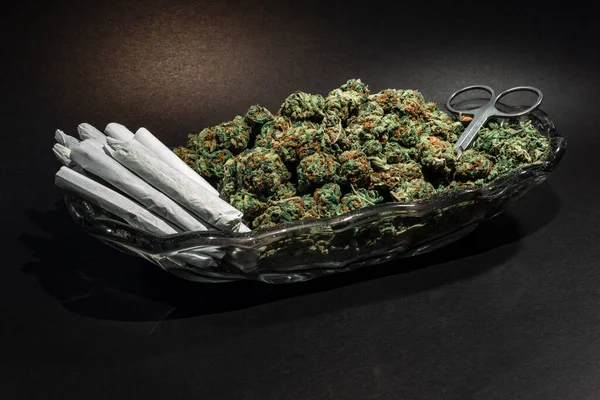 Plat en verre chic avec bourgeon de marijuana, ciseaux et une douzaine de joints — Photo