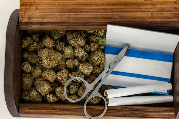 Yeşil marihuana tomurcuklarıyla dolu ahşap bir zula kutusu.