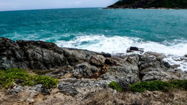 Phuket Tha 'daki Promthep' te rüzgarlı bir günde beyaz bir sahil şeridi.