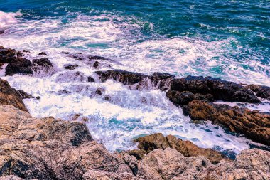Beyaz sular Promthep Burnu, Phuket Tayland 'ın güneyindeki kayalık kıyı şeridine çarpar.