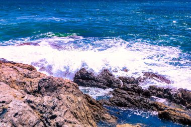 Beyaz sular Promthep Burnu, Phuket Tayland 'ın güneyindeki kayalık kıyı şeridine çarpar.