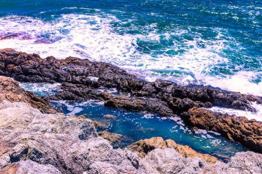 Beyaz sular Promthep Burnu, Phuket Tayland 'ın güneyindeki kayalık kıyı şeridine çarpar.