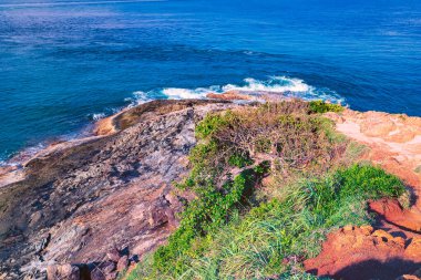 Beyaz sular Promthep Burnu, Phuket Tayland 'ın güneyindeki kayalık kıyı şeridine çarpar.