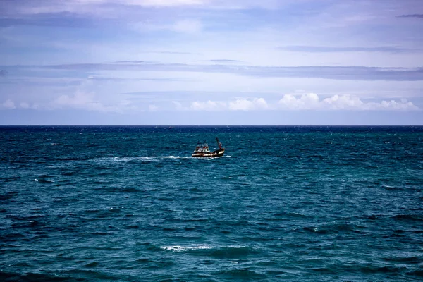 Phuket 'in güney kıyısında dalgalı sularda denize açılan bir balıkçı teknesi..