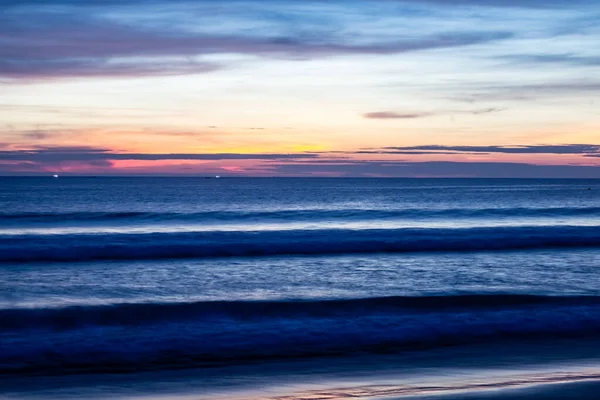 Atardecer sombreado azul en la playa de Karon sobre el océano Imágenes de stock libres de derechos
