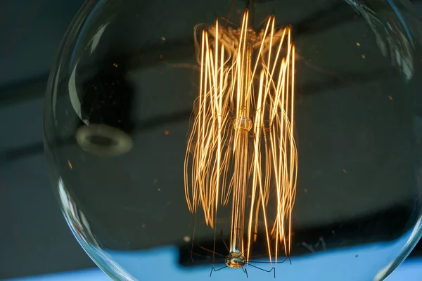 Amazing spiral electric current inside a retro crystal clear light bulb.