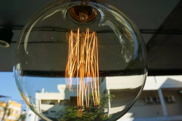 Amazing spiral electric current inside a retro crystal clear light bulb.