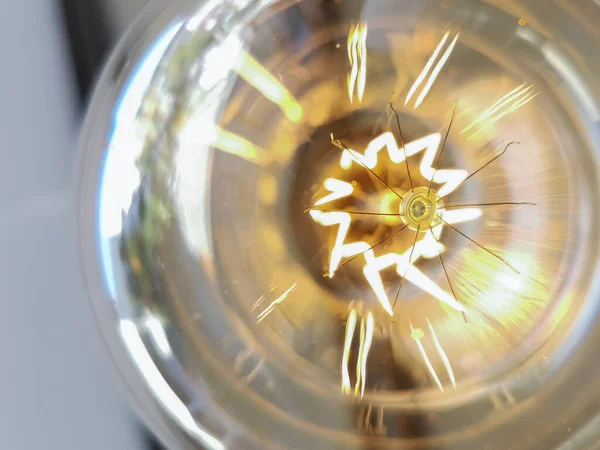 Amazing spiral electric current inside a retro crystal clear light bulb.