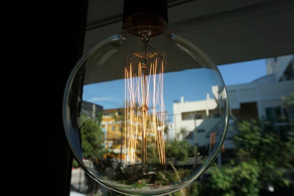 Amazing spiral electric current inside a retro crystal clear light bulb.