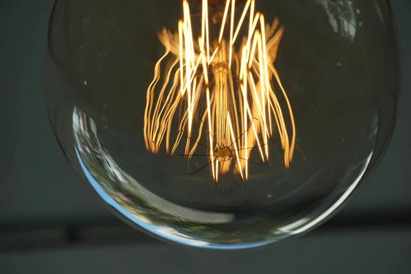 Amazing spiral electric current inside a retro crystal clear light bulb.