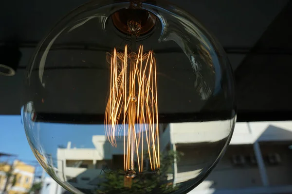 Amazing spiral electric current inside a retro crystal clear light bulb.