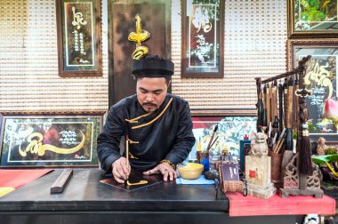 Hochiminh City - Vietnam: Genç adam geleneksel siyah kostüm çizim hat antik Allah Hochiminh City, Vietnam ile. 