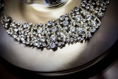 Diamond Jewelry Necklace around metal lamp base.	