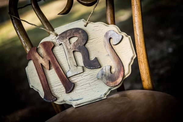 Rustic wedding sign sitting on a chair.