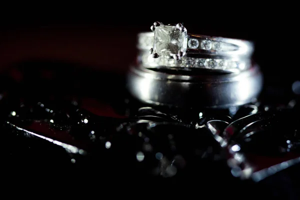 Diamond Wedding Rings in Black Textured Background — Stock Photo, Image