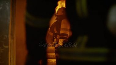 İki cesur itfaiye açık kapı girin ve yanan merdivenlerden çalıştırın. Bina yanıyor. Duman ve alevler her yerde açın. Ağır çekimde.