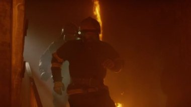 Cesur itfaiye yanan merdivenlerden çalıştırın. Ağır çekimde. Azgın ateştir her yerde görülen.