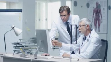 Kıdemli doktor ve Yardımcısı hastanın günlük kişisel bilgisayar üzerinde tartışmak.