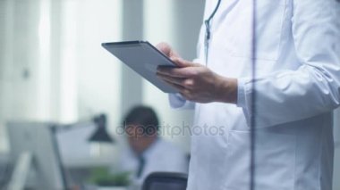 Kıdemli doktor tanı ve danışmanlık Tablet bilgisayarınız hakkında düşünme. Parlak ve Modern ofisinin olduğunu.