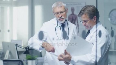İki uzman doktor hastanın günlük tartışıyor. Her ikisi are kıdemli ve deneyimli. Onların ofis Modern ve saygıdeğer görünüyor.
