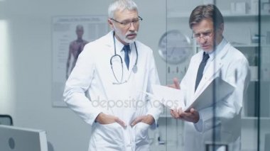 İki uzman doktor hastanın günlük tartışıyor. Her ikisi are kıdemli ve deneyimli. Onların ofis Modern ve saygıdeğer görünüyor.