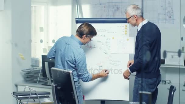 En la Oficina de Ingeniería Arquitectónica Dos Ingenieros Senior que Trabajan con Borradores en una pizarra blanca. Su oficina parece minimalista y moderna . — Vídeos de Stock