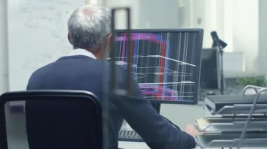 3d modeli ile kişisel bilgisayarında çalışan üst düzey mimari mühendis Backview. Ayrıca asistanı ofiste geldi ve onun masasında gerçekleşti.