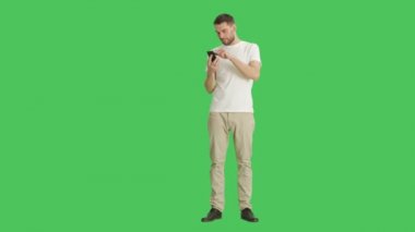Düşük ihtimal işaret jest üstünde onun Smartphone Swiping kullanarak rahat bir adam. Yeşil ekran arka plan olduğunu.