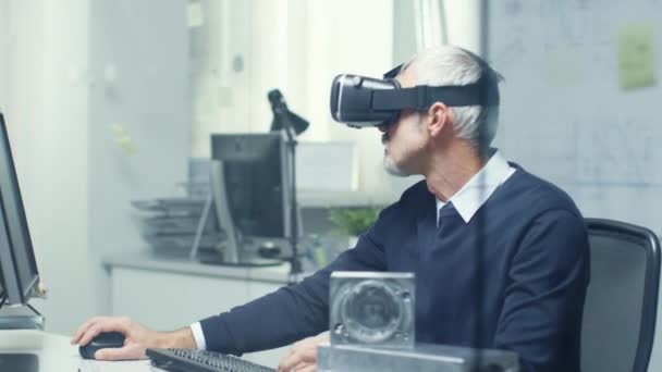 Virtual-Reality-Ingenieur arbeitet mit eingeschalteter VR-Brille und programmiert gleichzeitig auf seinem PC. — Stockvideo